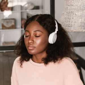 Black woman with headphones and eyes closed during an online EMDR therapy session