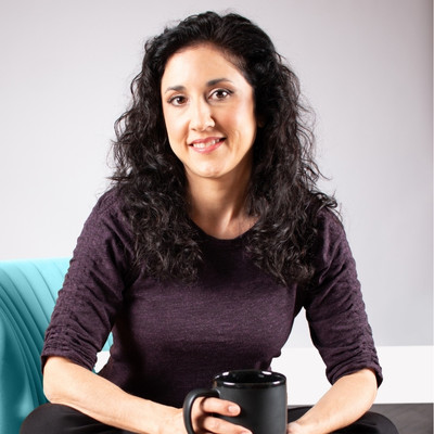 Licensed Mental Health Counselor Marisa Knight sitting cross legged and holding a black mug